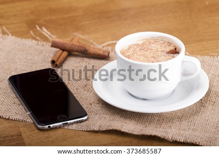 High angle view of smart phone with blank screen and espresso coffee cup on wooden surface