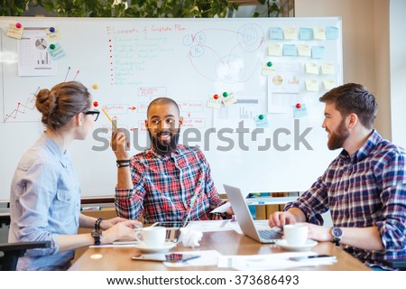 Multiethnic group of young people sitting in conference room and brainstorming on business meeting  Royalty-Free Stock Photo #373686493