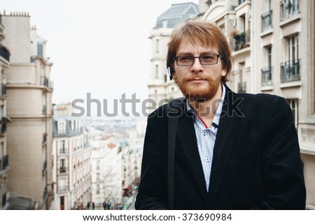 Handsome Pensive Bearded Man Wearing Headset. Tourist on Vacation in Paris, France. City Lifestyle. 