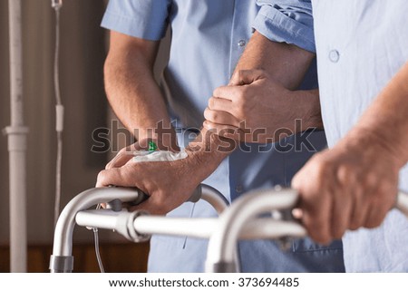 Close-up of disabled person walking with assistance
