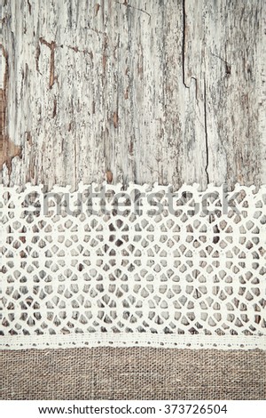 Lace fabric on the old wooden background
