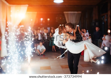 Happy bride and groom and their first dance, wedding in the elegant restaurant with a wonderful light and atmosphere Royalty-Free Stock Photo #373734994