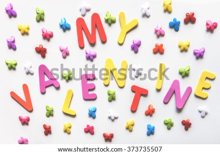 Text of colorful letters My Valentine on the white background with multicolored small butterflies. Holiday Valentine's Day. For greeting card