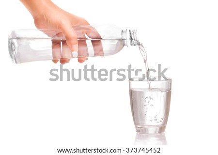 Woman's hand holding a bottle of water Pouring water into a glass Royalty-Free Stock Photo #373745452