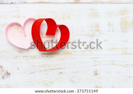 red and pink paper heart on white wood background