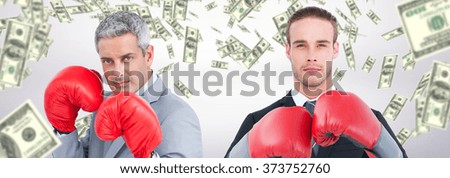 Businessman with boxing gloves against dollars falling