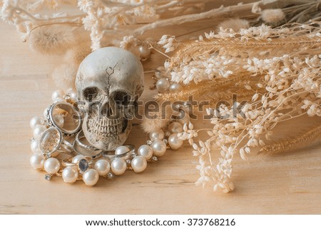 he skull with pearl necklace and rings on wooden - Still Life