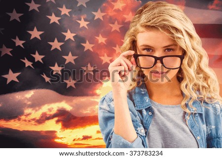 Portrait of businesswoman wearing eyeglasses posing against composite image of united states of america flag