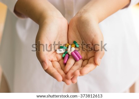 doctor hand holding a lot of medicine pills