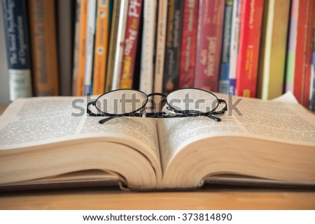 Glasses and book on background bookcase