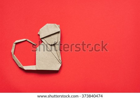 Folded paper origami monkey on red eco background. Vertical postcard template.