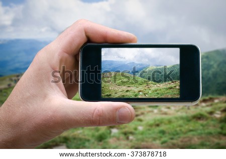phone in hand man (photographing the landscape) photos from your phone, Self, photographing on the phone, the man photographs the mountain landscape on the phone (smartphone)