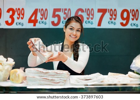 Portrait of female seller offering salo and lard in butchery