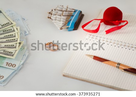 background, money , wedding rings , notebook notes pen, prepare for the wedding, plan a wedding , honeymoon