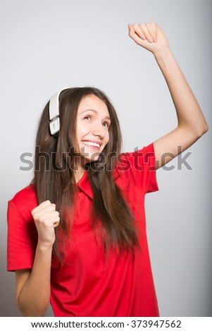 nice girl dancing to music with headphones on a grey background