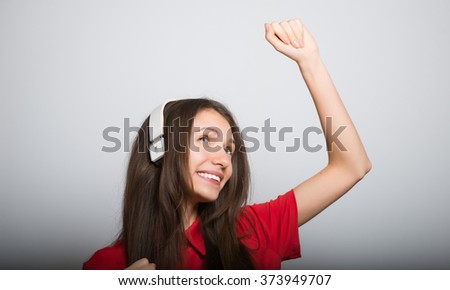 nice girl dancing to music with headphones on a grey background