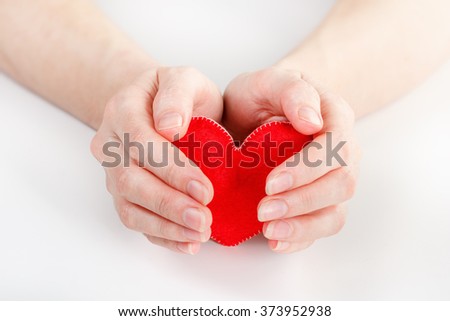 Woman holding heart symbol in her hands. Concept of health, protection and love. 
