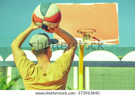Young handsome guy playing basket on the beach -  Healthy lifestyle sport recreation concept - Vintage retro filter look 