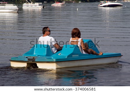 senior couple on pedalo also called pedal boat on a lake at daytime  Royalty-Free Stock Photo #374006581