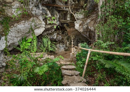 TampangAllo burial cave of the royal family. Pile of skulls by the entrance, coffins are placed in caves or hanging from cliff and statues tau-tau guard the graves. Tana Toraja. Sulawesi. Indonesia