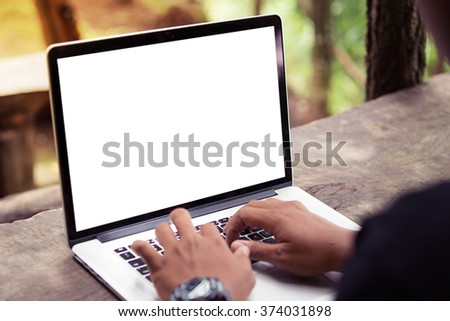 A man is working using laptop at park / outdoor, blank screen for background