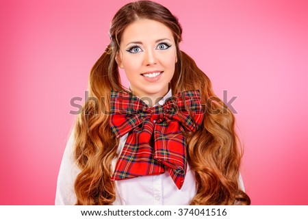 Portrait of a pretty smiling teen girl in school uniform posing over pink background. Anime style. 