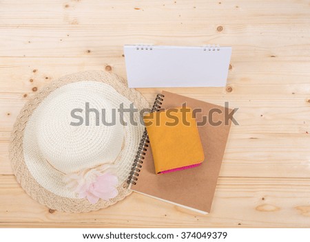Sun hat , calendar  and  wallet  on wooden background travel concept
