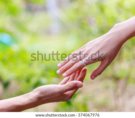 Helping hands - hands praying against nature background