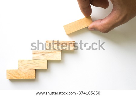 Hand aranging wood block stacking as step stair. Business concept for growth success process. Royalty-Free Stock Photo #374105650