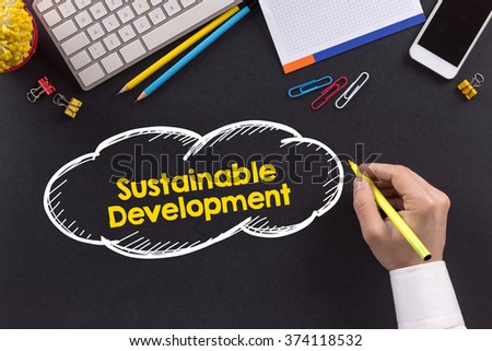 Man working on desk and writing Sustainable Development