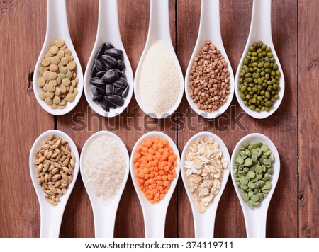 Cereals in ceramic bowls on wooden background.