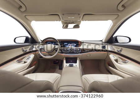 Car interior luxury. Beige comfortable seats, steering wheel, dashboard, climate control, speedometer, display, wood decoration & orange ambient light Royalty-Free Stock Photo #374122960