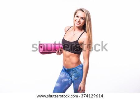 Attractive cheerful young sportswoman holding yoga mat isolated over white background