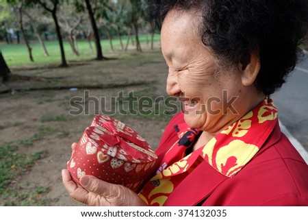 Portrait of Asian Senior holding a gift box