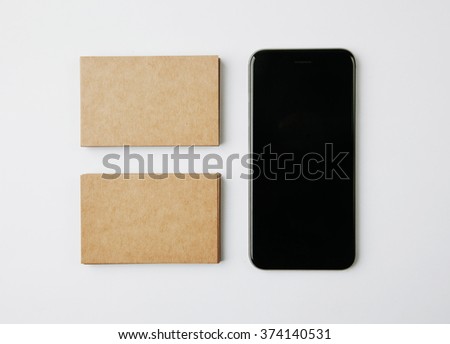 Two stack of craft business cards and smartphone on white background. Horizontal
