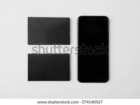Two stack of blank black business cards and smartphone on white background. Horizontal