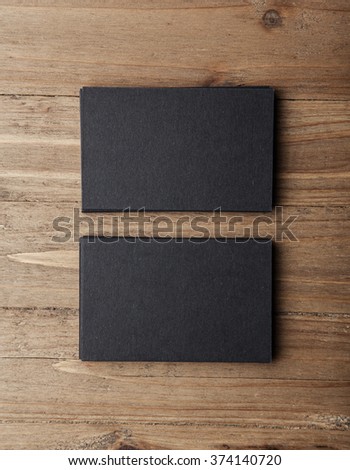 Two stack of blank black business cards on wooden background Vertical