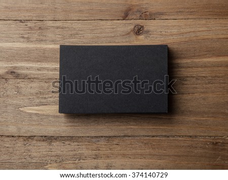 Stack of blank black business cards on wooden background Horizontal