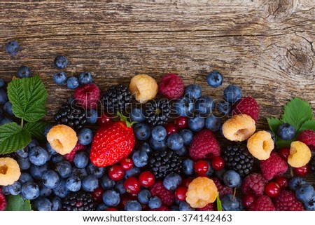 pile of fresh  berries mix on wooden tabletop with copy space