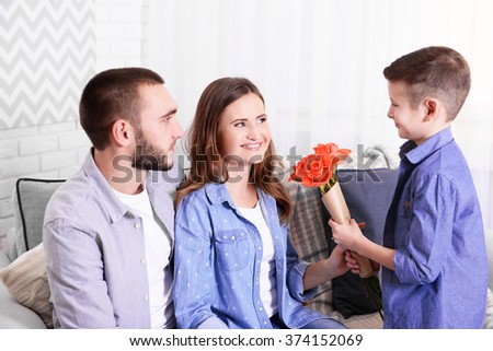 Husband and son giving roses to wife