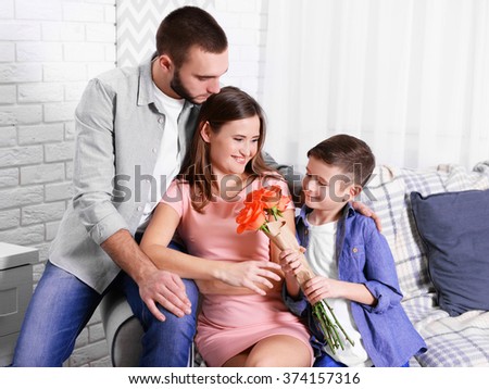 Photo of happy family sitting on the sofa at home