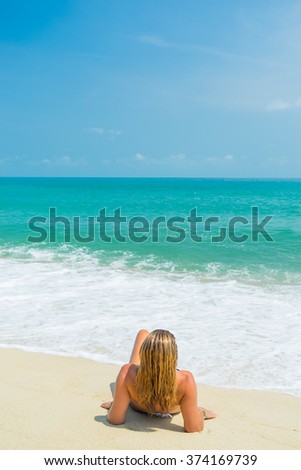 Back view of a Woman sitting on the beach