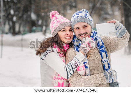 couple in love smiling and making selfie in winter outdoors