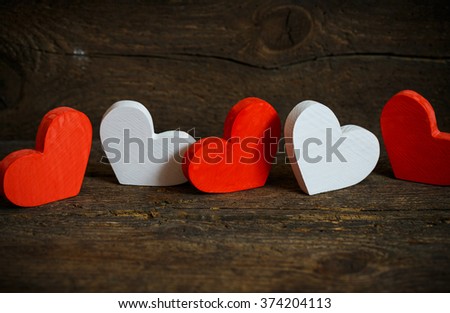 Red and white hearts on old shabby wooden background. Concept of Valentines day