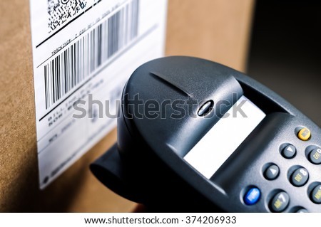 Barcode reader scanning a UPC label on a box.  Royalty-Free Stock Photo #374206933