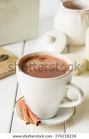 Hot Chocolate in White Beautiful Cup on Light White Wooden Background, Close-up