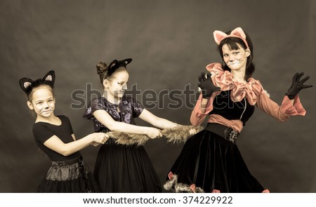 Episode of funny play in retro style. Three girls in cat costumes on black background.