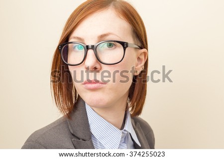 Beautiful business woman with red hair and blue eyes wearing glasses.