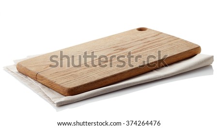 Brown wooden cutting board on cotton napkin isolated on white background. Clipping path Royalty-Free Stock Photo #374264476