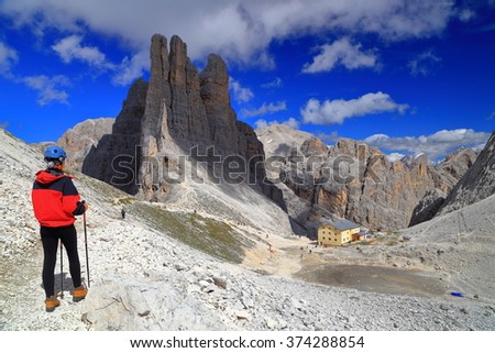 Rocky valley and woman climber watching the Vajolet towers in Catinaccio mountains, Dolomite Alps, Italy